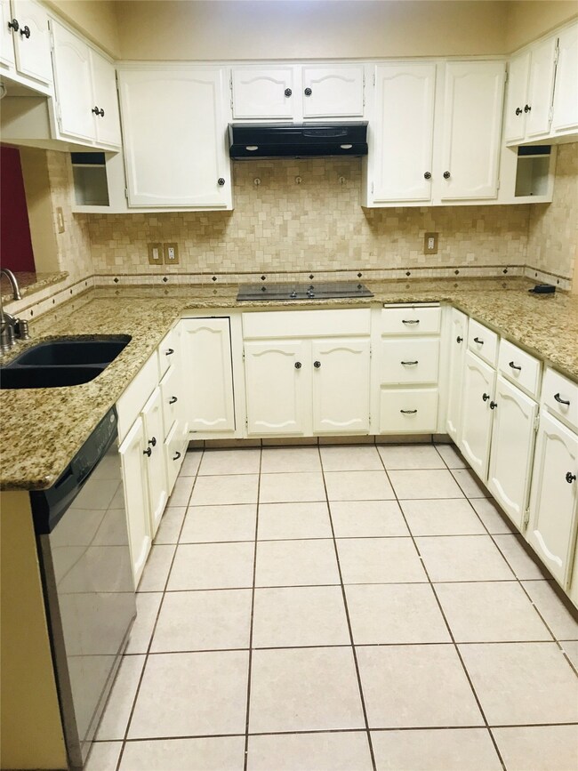 Kitchen features granite countertops and tile backsplash.