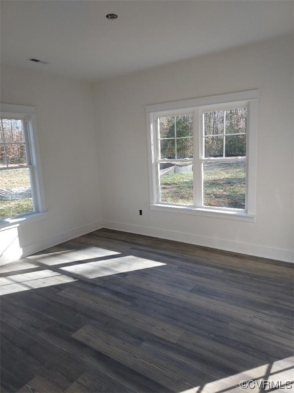 Empty room with dark wood-type flooring