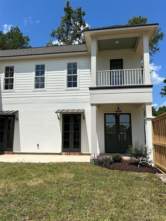 Back of house featuring a yard, a balcony, and fre