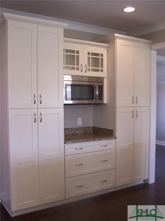 Microwave area with numerous cabinets / drawers.