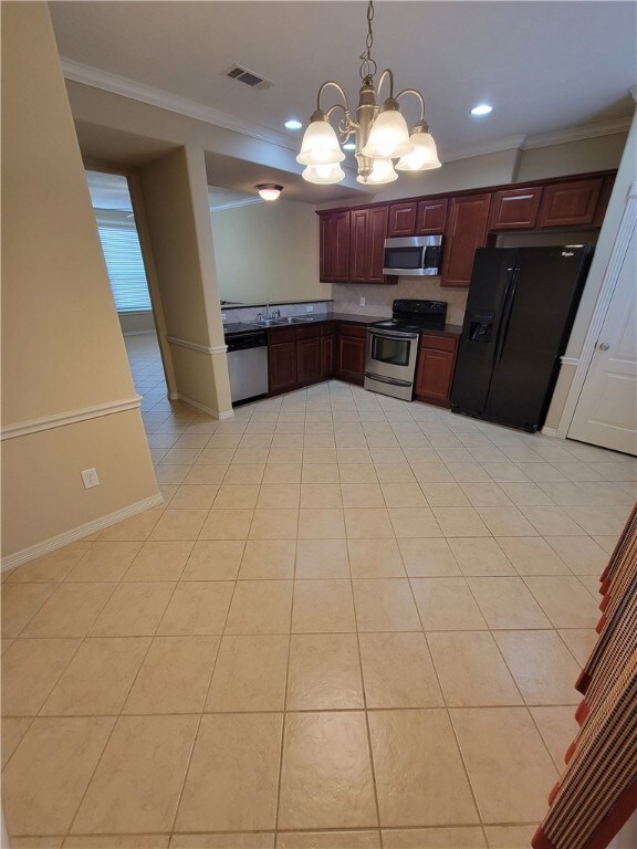 Kitchen featuring ornamental molding, stainless steel appliances, pendant lighting, a chandelier, and dark countertops