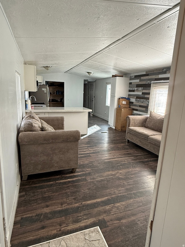 Living area with dark wood-style floors and a textured ceiling