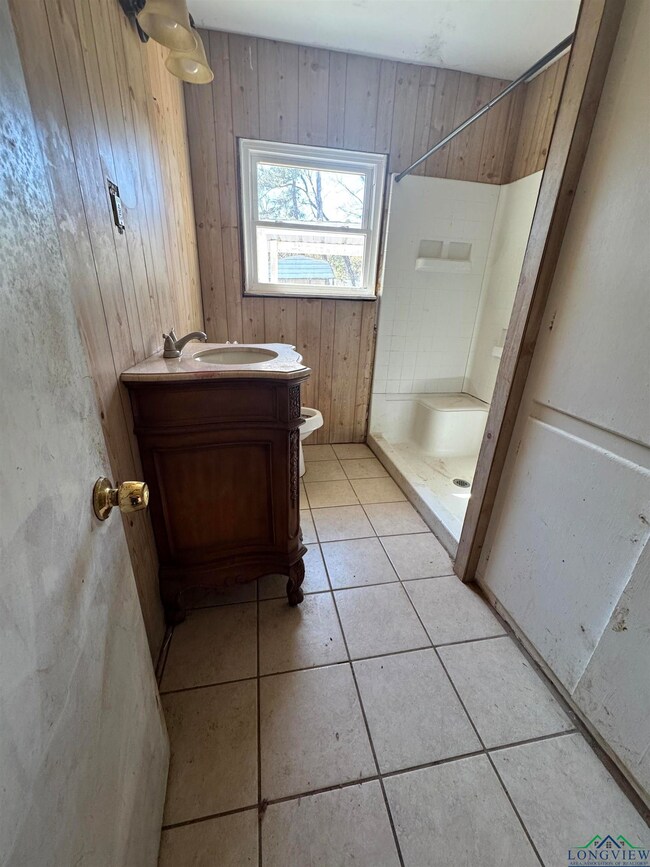 Full bath featuring vanity, wooden walls, a stall 