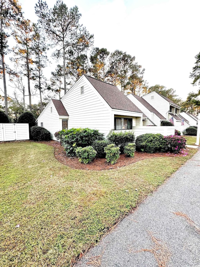 View of side of property featuring a lawn