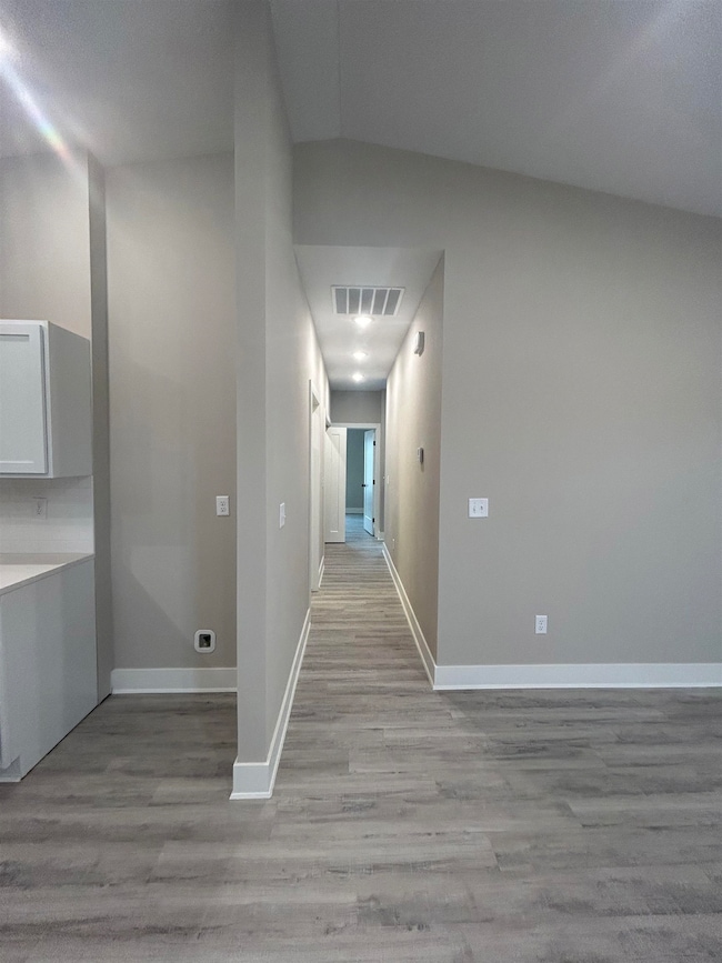 Hallway featuring light wood finished floors and baseboards