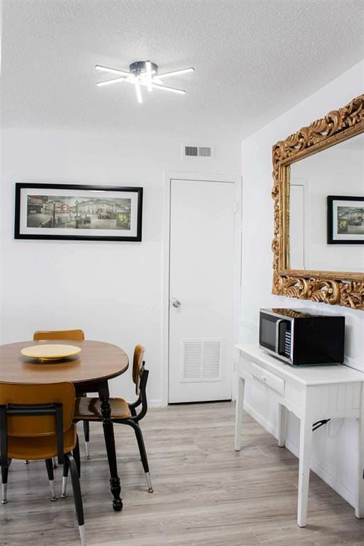 Dining room featuring a textured ceiling and light wood-type flooring