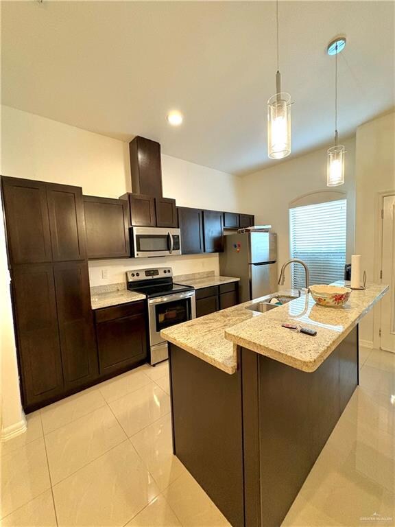 Kitchen with pendant lighting, sink, a kitchen island with sink, and appliances with stainless steel finishes