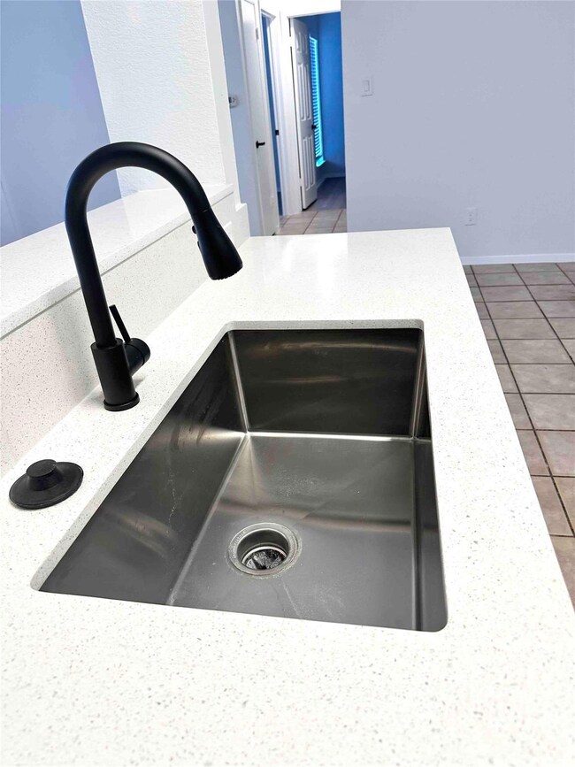 Kitchen view of light stone countertops and a sink