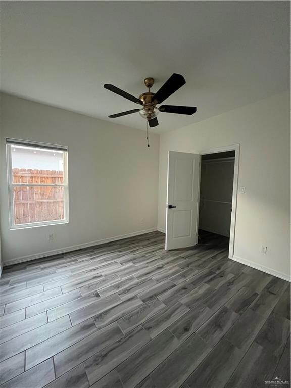 Unfurnished bedroom featuring wood finished floors and a ceiling fan