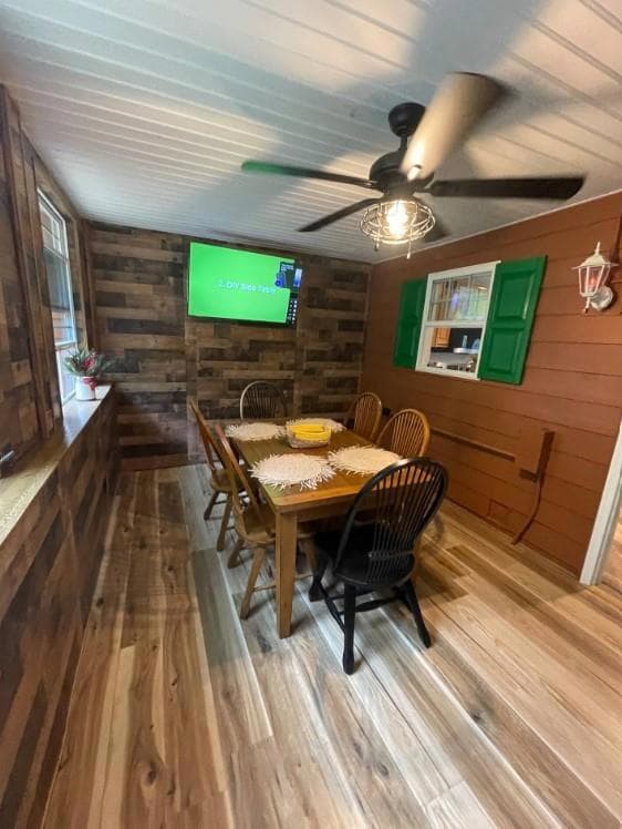 Dining space with wooden walls, wood finished floo