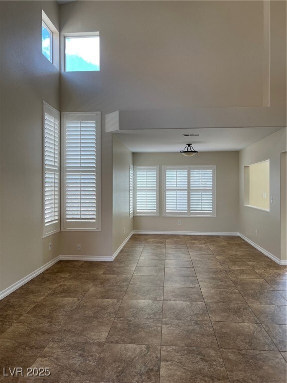 Spare room with visible vents, baseboards, and a t
