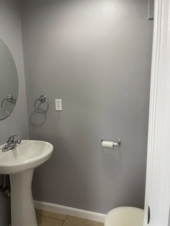 Half bath with baseboards and light tile patterned floors