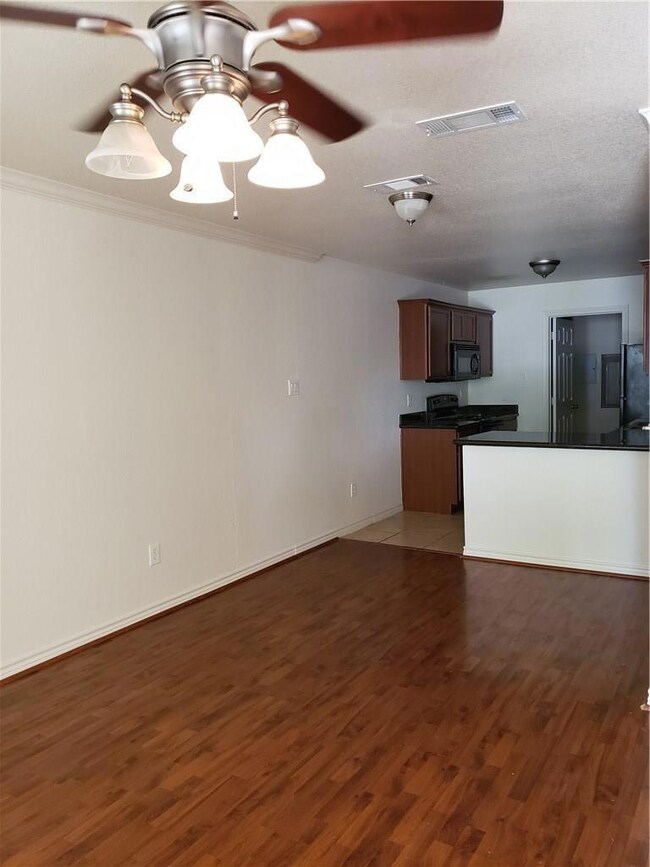 Kitchen featuring a textured ceiling, black applia