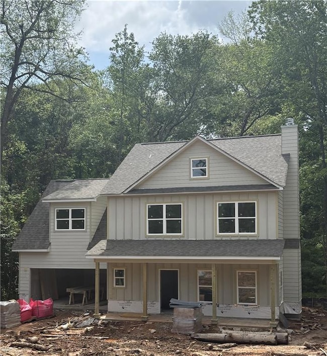 View of front of house featuring board and batten siding, a shingled roof, and a porch