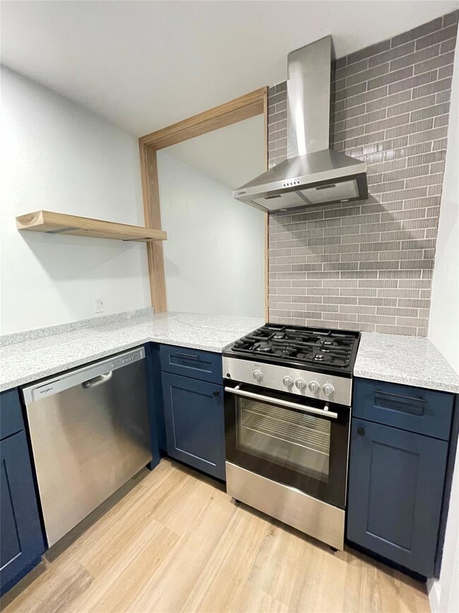 Kitchen with wall chimney exhaust hood, stainless
