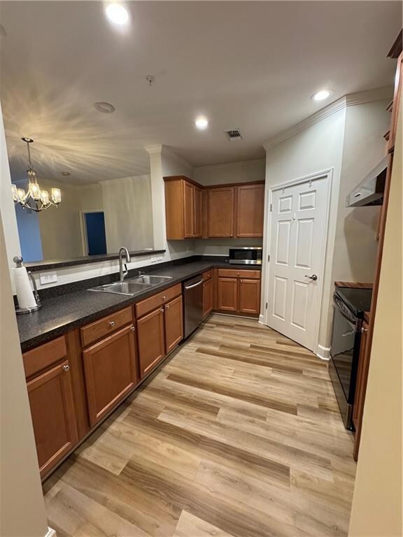 Kitchen with brown cabinets, stove, a sink, ventil