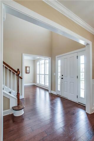 Large friendly 2-story entry. Notice the 5' plank flooring with hardwood continuing up the stairs. As you look up, you'll notice a trey ceiling in the dining room, master & master bath. There's crown molding through out the house. 