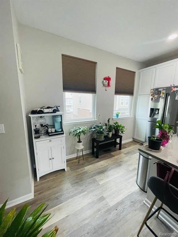 Living area with light wood finished floors and baseboards