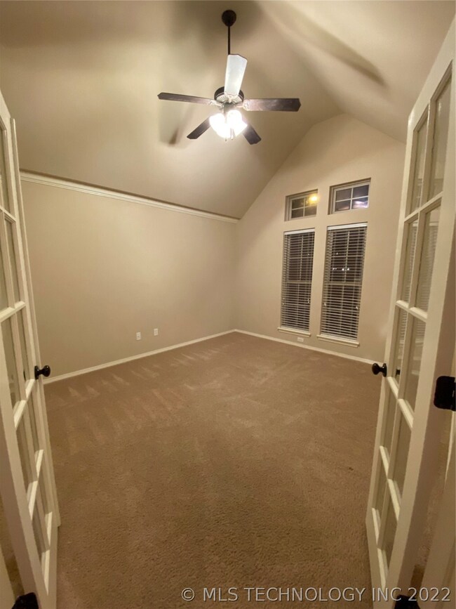 Office features vaulted ceiling and French doors.