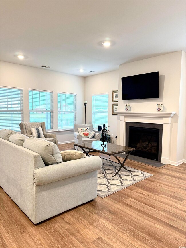 Living area with wood finished floors, a fireplace, and recessed lighting