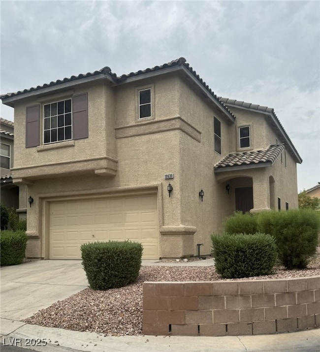 Mediterranean / spanish home featuring a tile roof, stucco siding, concrete driveway, and a garage