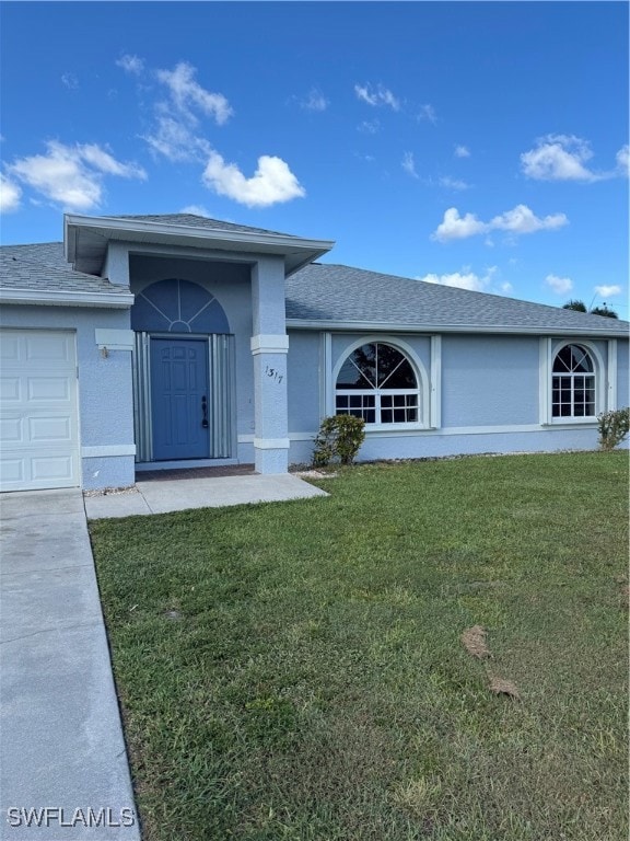 View of front of home featuring a front yard and a garage