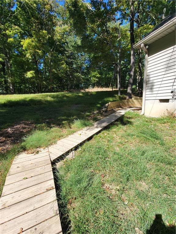 View of green lawn with view of wooded area