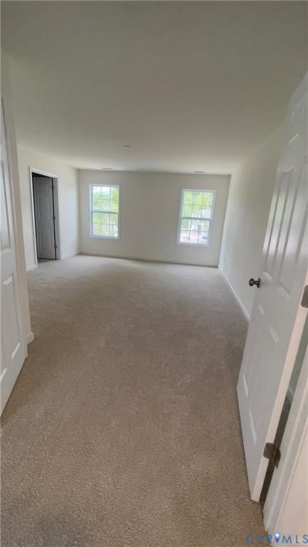 Empty room featuring healthy amount of natural light and carpet floors