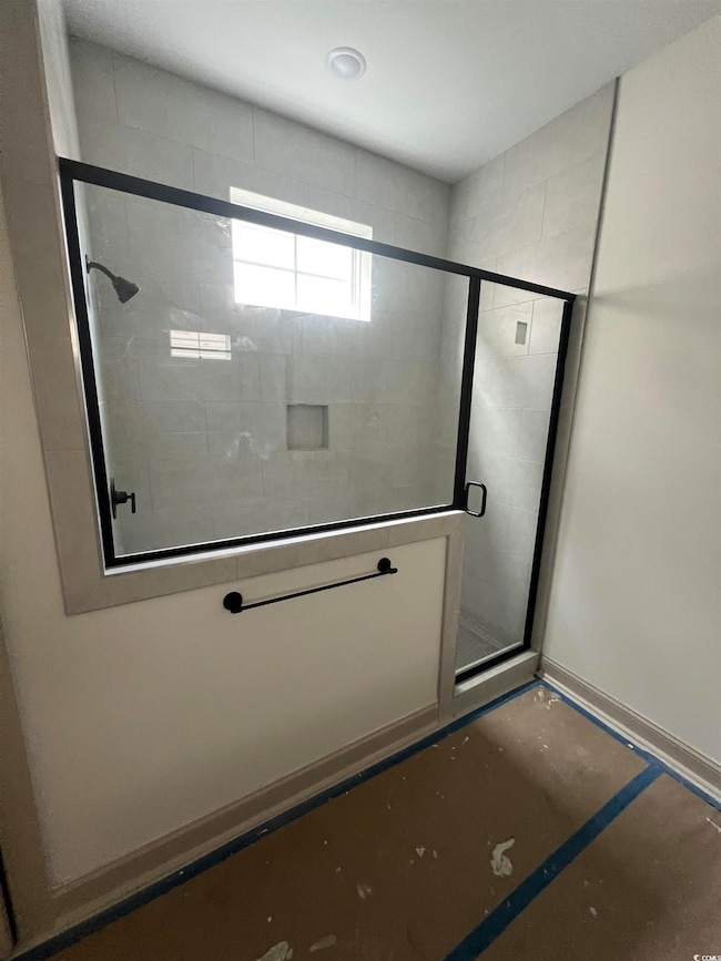 Bathroom with a stall shower and baseboards
