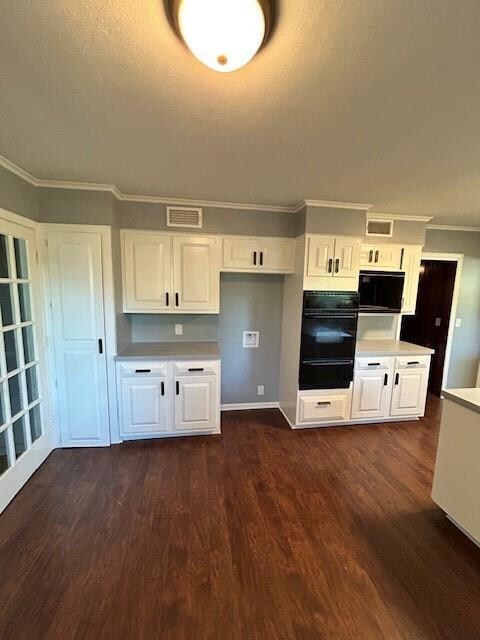 Kitchen with ornamental molding, dark wood-type fl