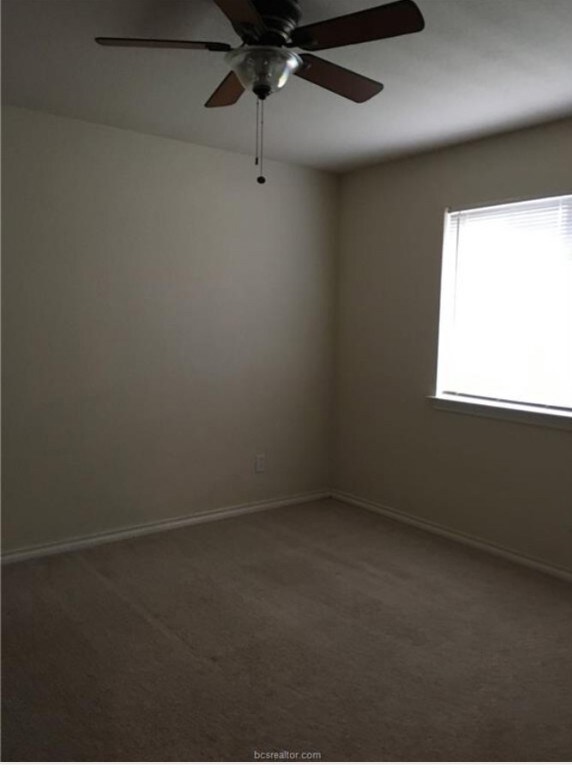 Empty room featuring baseboards, ceiling fan, and