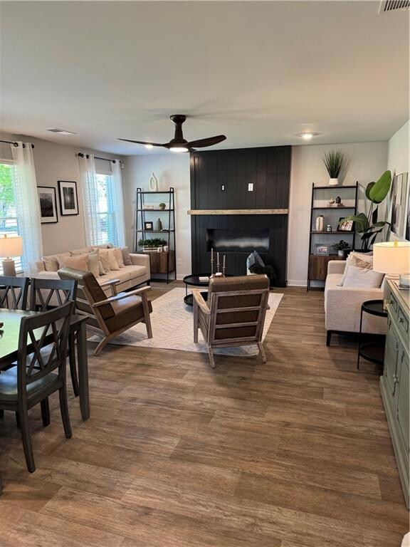 Living area featuring a large fireplace, ceiling f