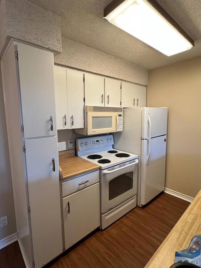 Kitchen with white appliances, light countertops,