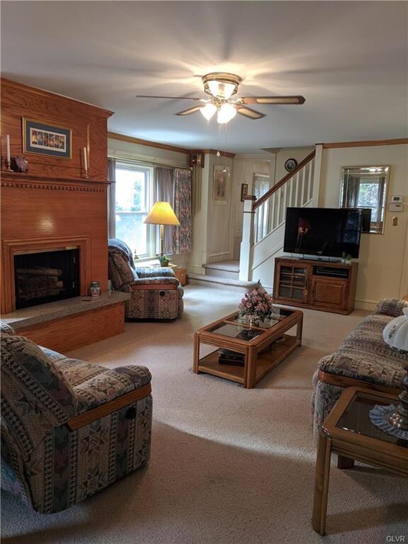 Large open living room with crown molding and fire