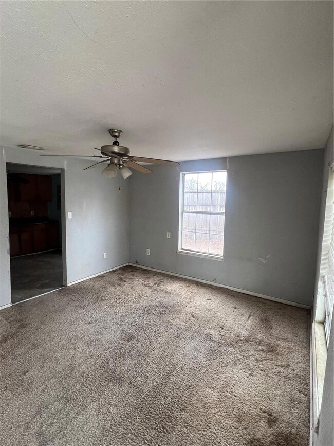 Carpeted empty room with ceiling fan and a texture