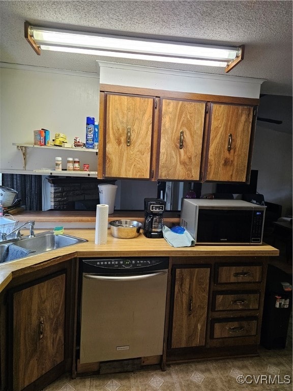 Kitchen featuring dishwashing machine, sink, and a