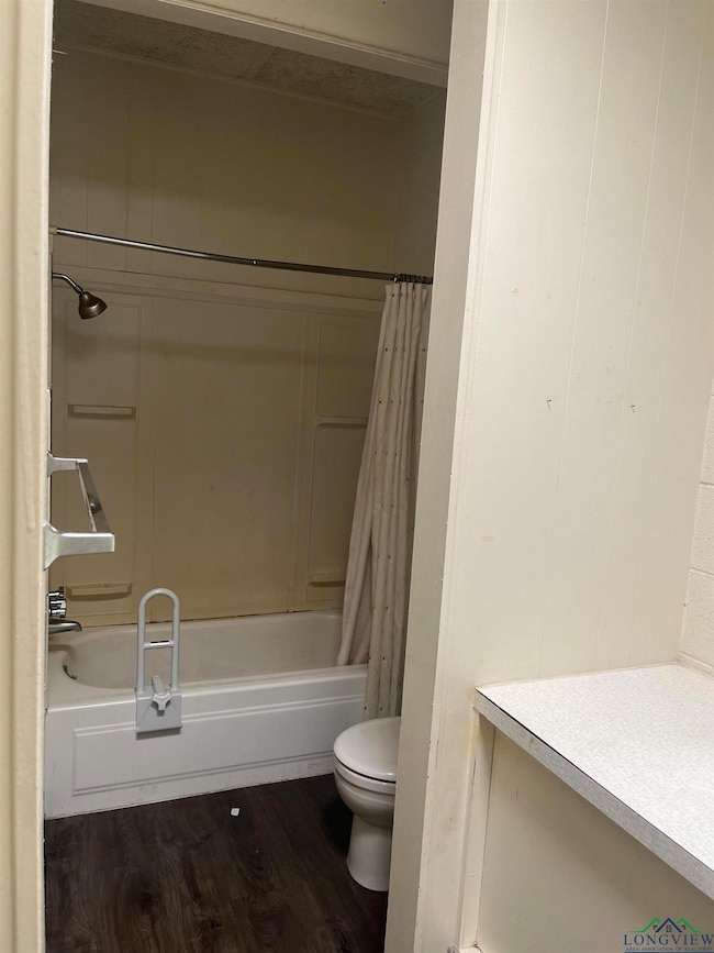 Bathroom featuring dark wood-type flooring, shower / bath combo, and vanity