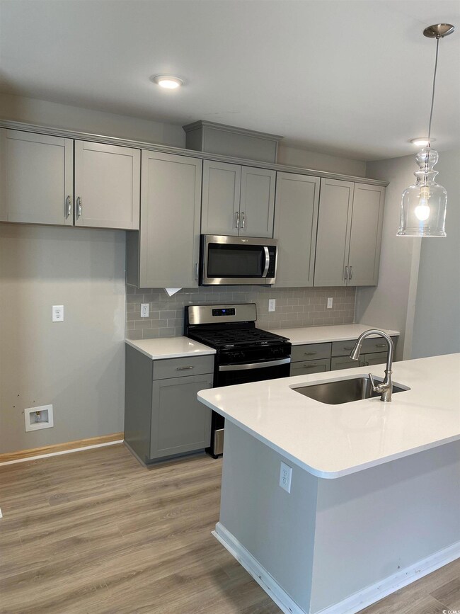 Kitchen with sink, light hardwood / wood-style flo