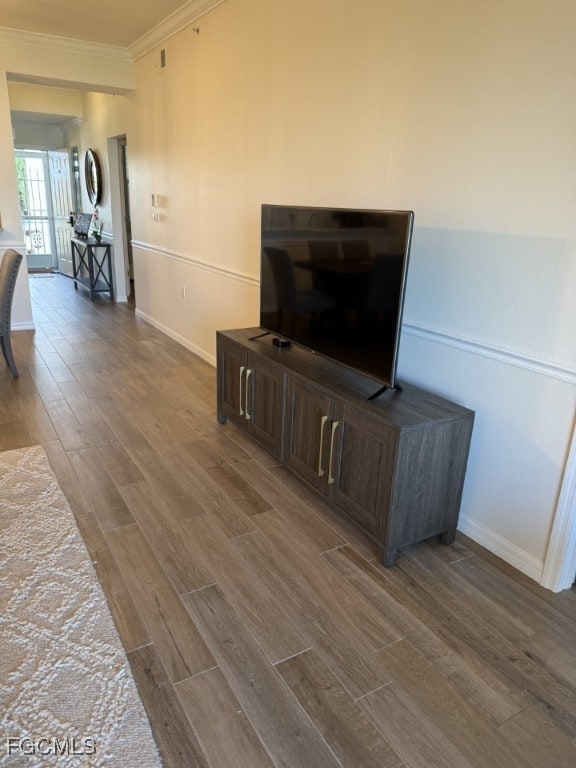 Living area featuring dark wood finished floors and crown molding