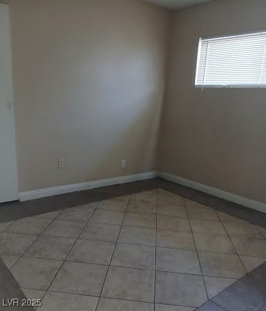Empty room with light tile patterned floors and ba