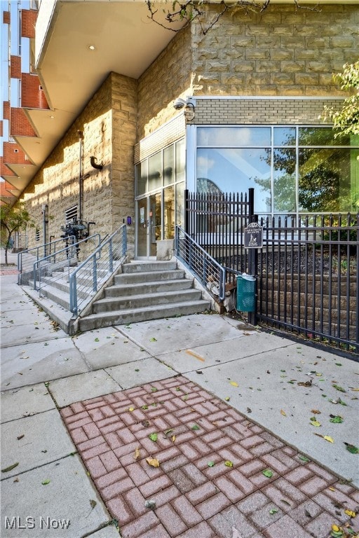 Entrance to property with stone siding, brick siding, and a patio area