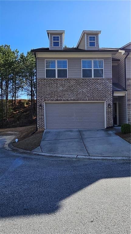View of front of property with a garage, brick sid