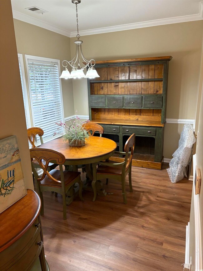 Dining area with crown molding, dark hardwood / wo