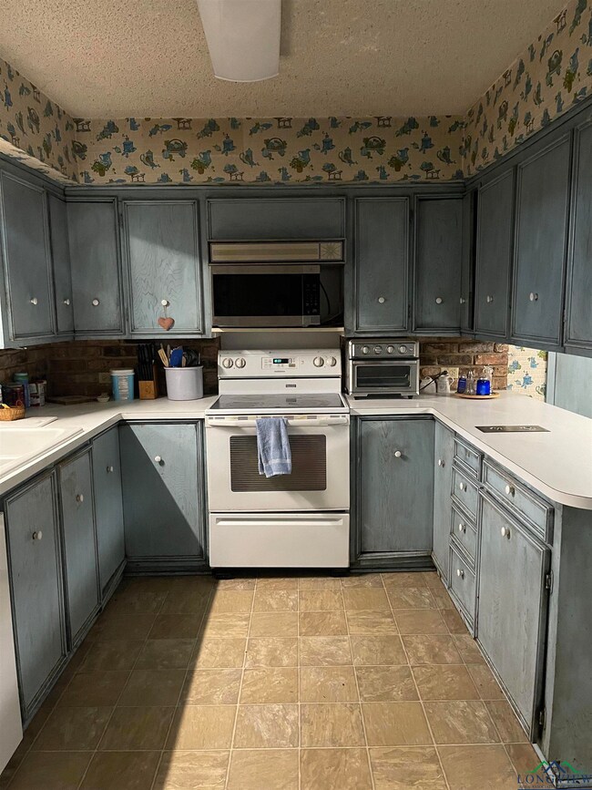Kitchen with white electric range oven, a textured
