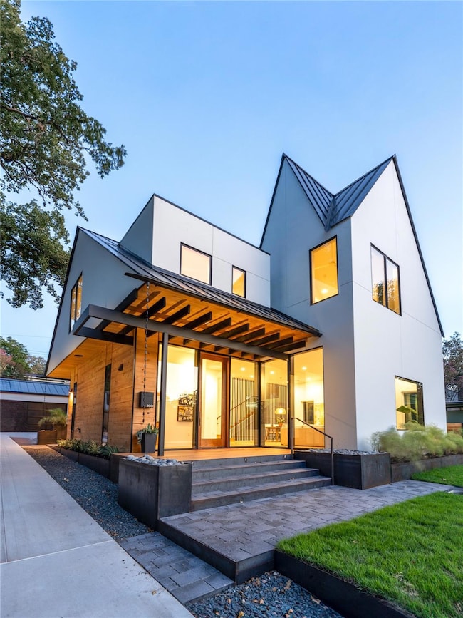 Rear view of property featuring a standing seam r