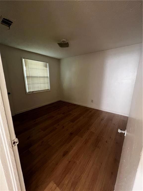 Empty room featuring dark hardwood / wood-style floors