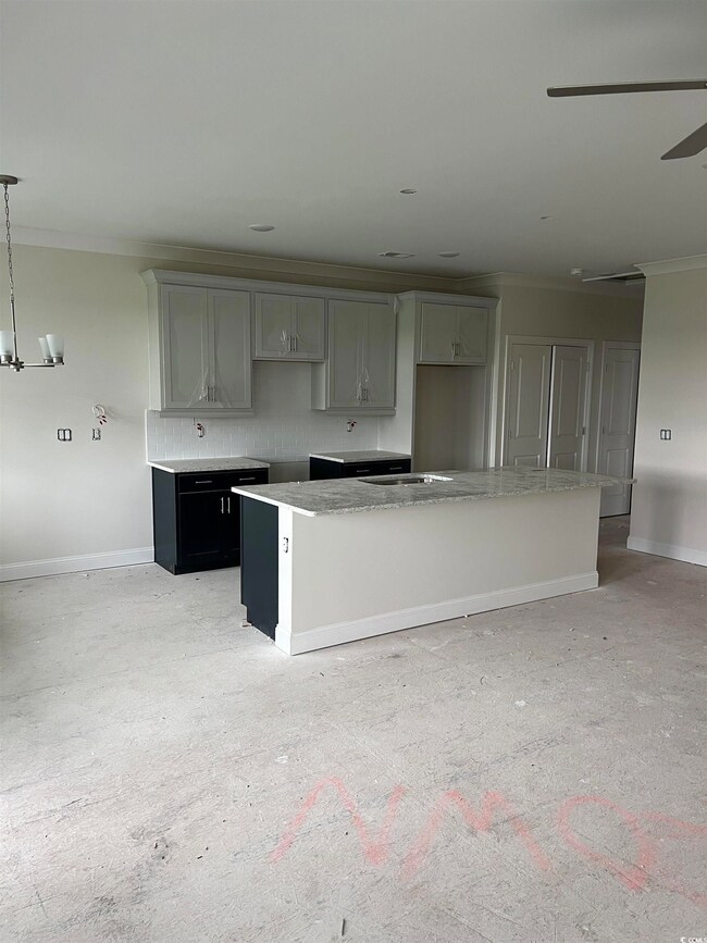 Kitchen featuring ornamental molding, baseboards, a kitchen island, gray cabinetry, and backsplash