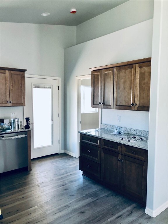 Kitchen featuring dishwasher, dark wood-style floo