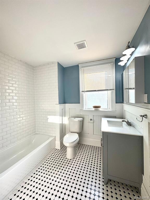 Full bathroom with wainscoting, vanity, and bathing tub / shower combination