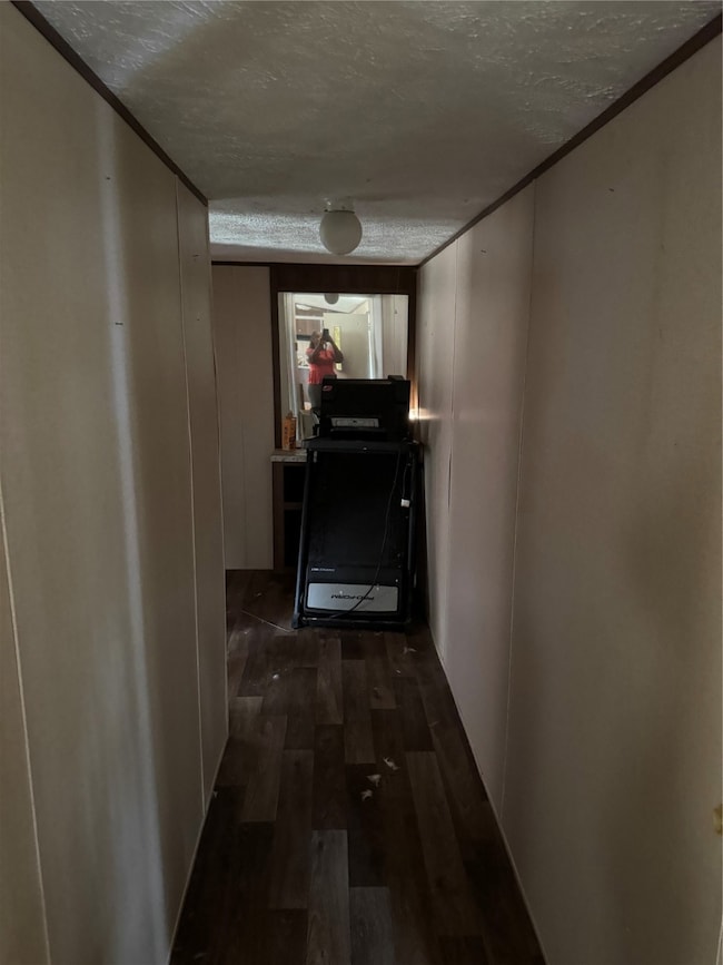 Hall with a textured ceiling and dark wood-style floors